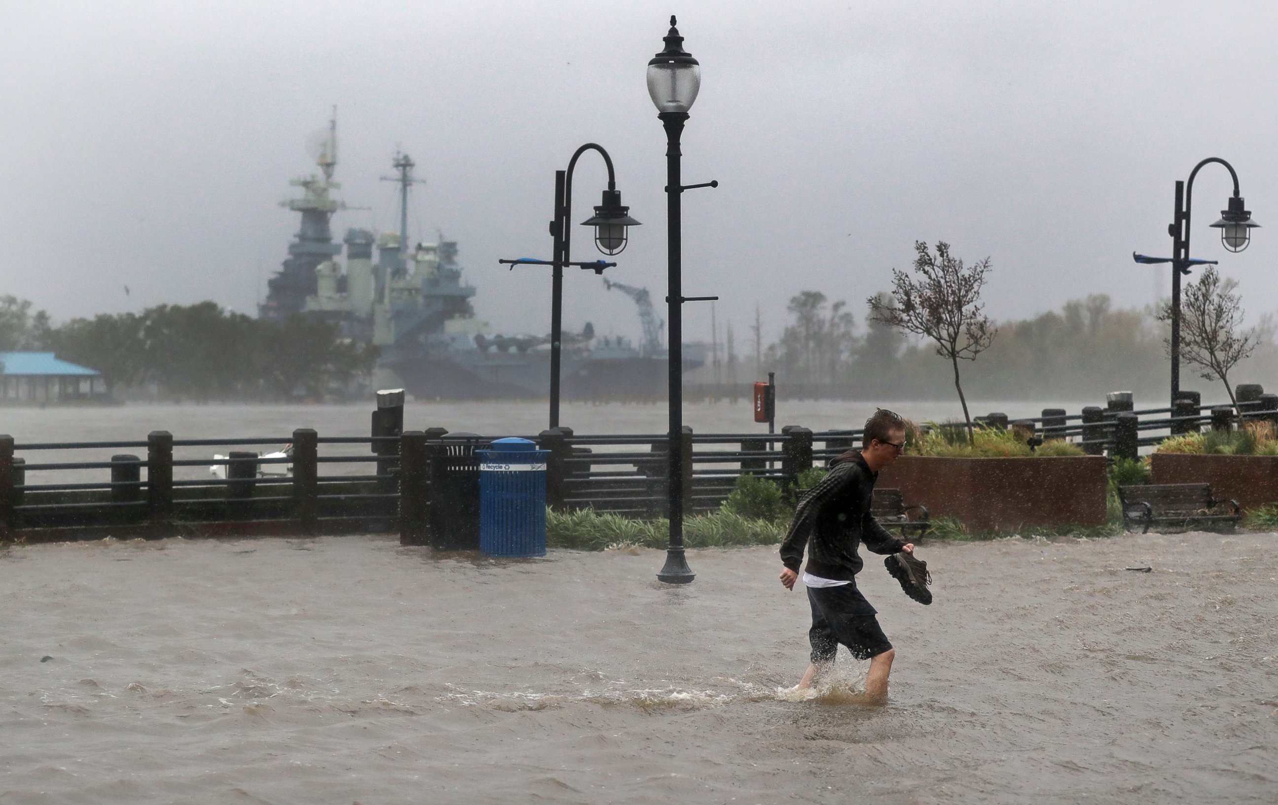 PHOTO: A man crosses a flooded street in downtown Wilmington, N.C., after Hurricane Florence made landfall Friday, Sept. 14, 2018.