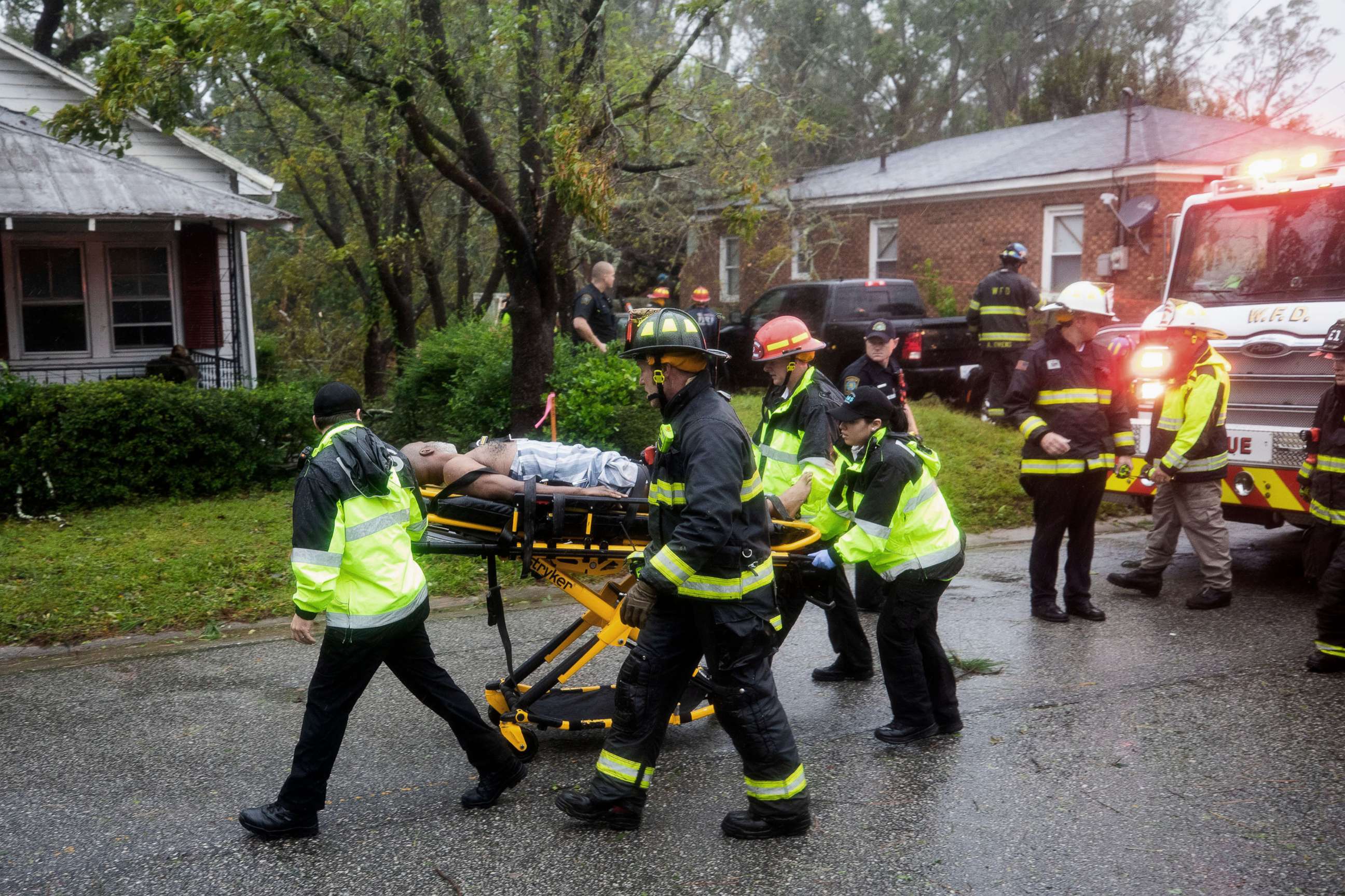 PHOTO: Rescue workers rush a man to an ambulance after a giant tree fell on a house in Wilmington, N.C. as Hurricane Florence came ashore, Sept. 14, 2018.
