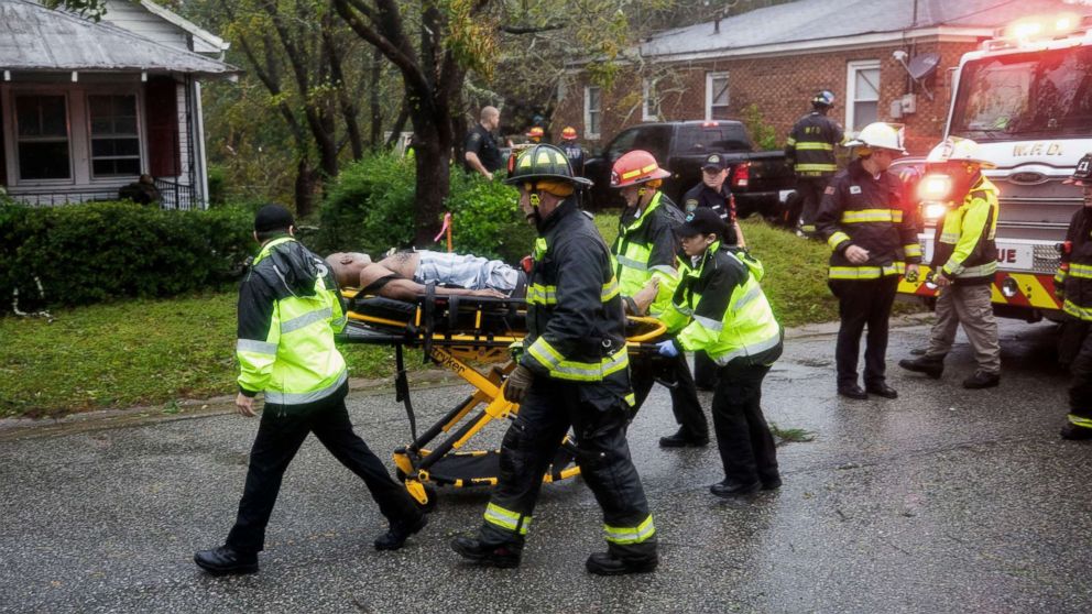 PHOTO: Rescue workers rush a man to an ambulance after a giant tree fell on a house in Wilmington, N.C. as Hurricane Florence came ashore, Sept. 14, 2018.