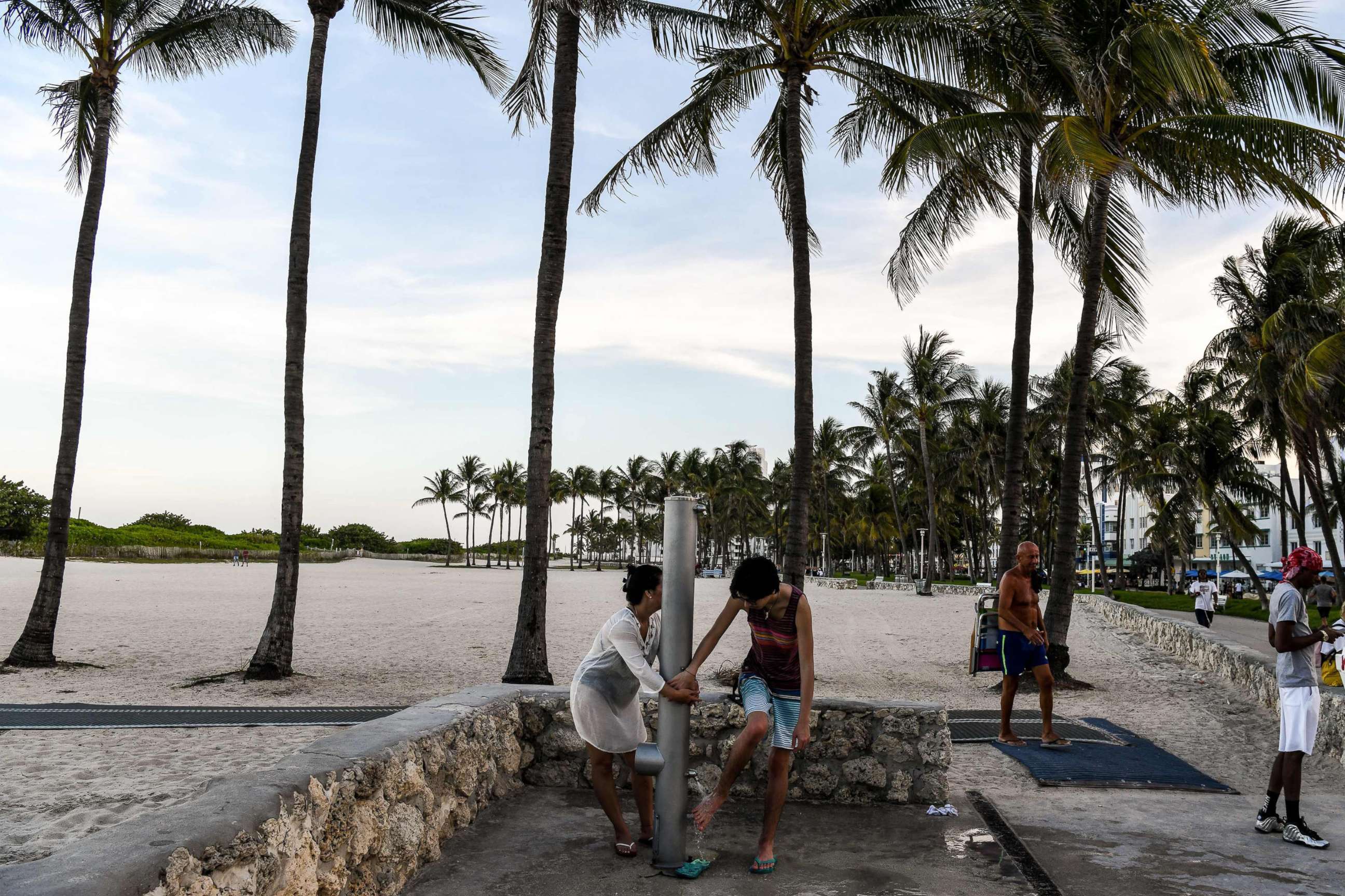 PHOTO: People rinse their feet in Miami, June 24, 2020. With coronavirus cases surging across the US South and West, officials are once again imposing tough measures, from stay-at-home advice in worst-hit states to quarantine.