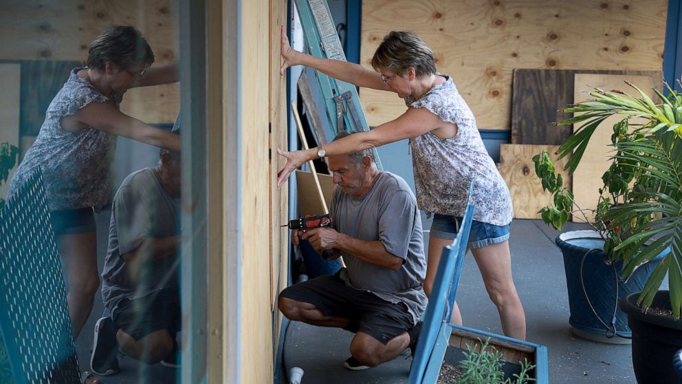 PHOTO: Frederic Herodet and Mary Herodet board up their Gulf Bistro restaurant as they prepare for the possible arrival of Hurricane Ian, Sept. 27, 2022, in St. Petersburg Beach, Fla.