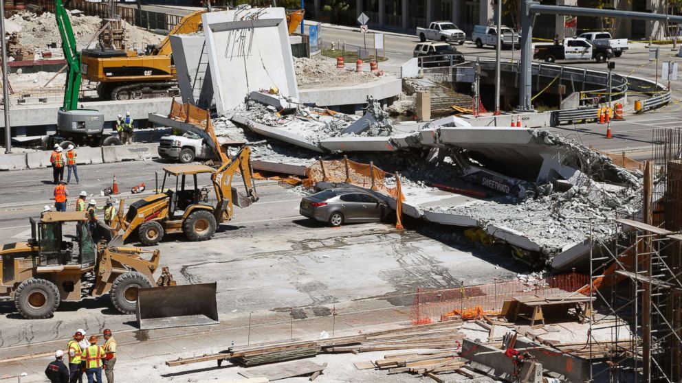 PHOTO: Crushed cars are shown under a section of a collapsed pedestrian bridge, March 16, 2018 near Florida International University in Miami.