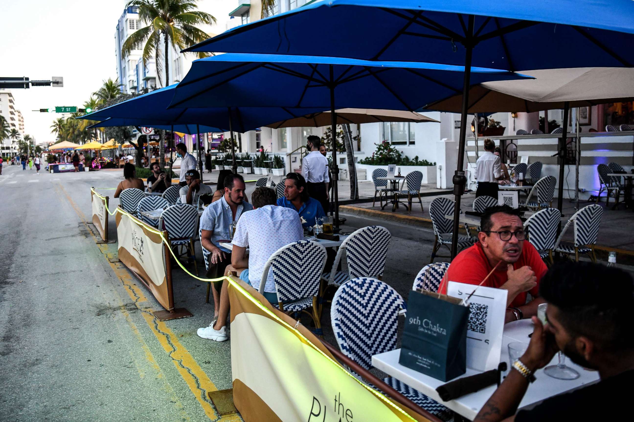 PHOTO: People eat in the outdoor dining area of a restaurant on Ocean Drive in Miami Beach, Florida on June 24, 2020.