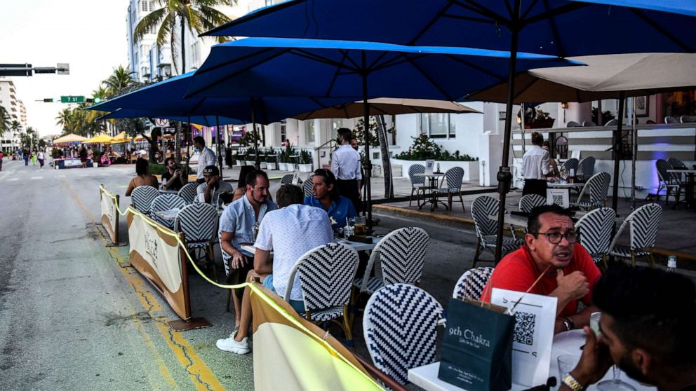 PHOTO: People eat in the outdoor dining area of a restaurant on Ocean Drive in Miami Beach, Florida on June 24, 2020.