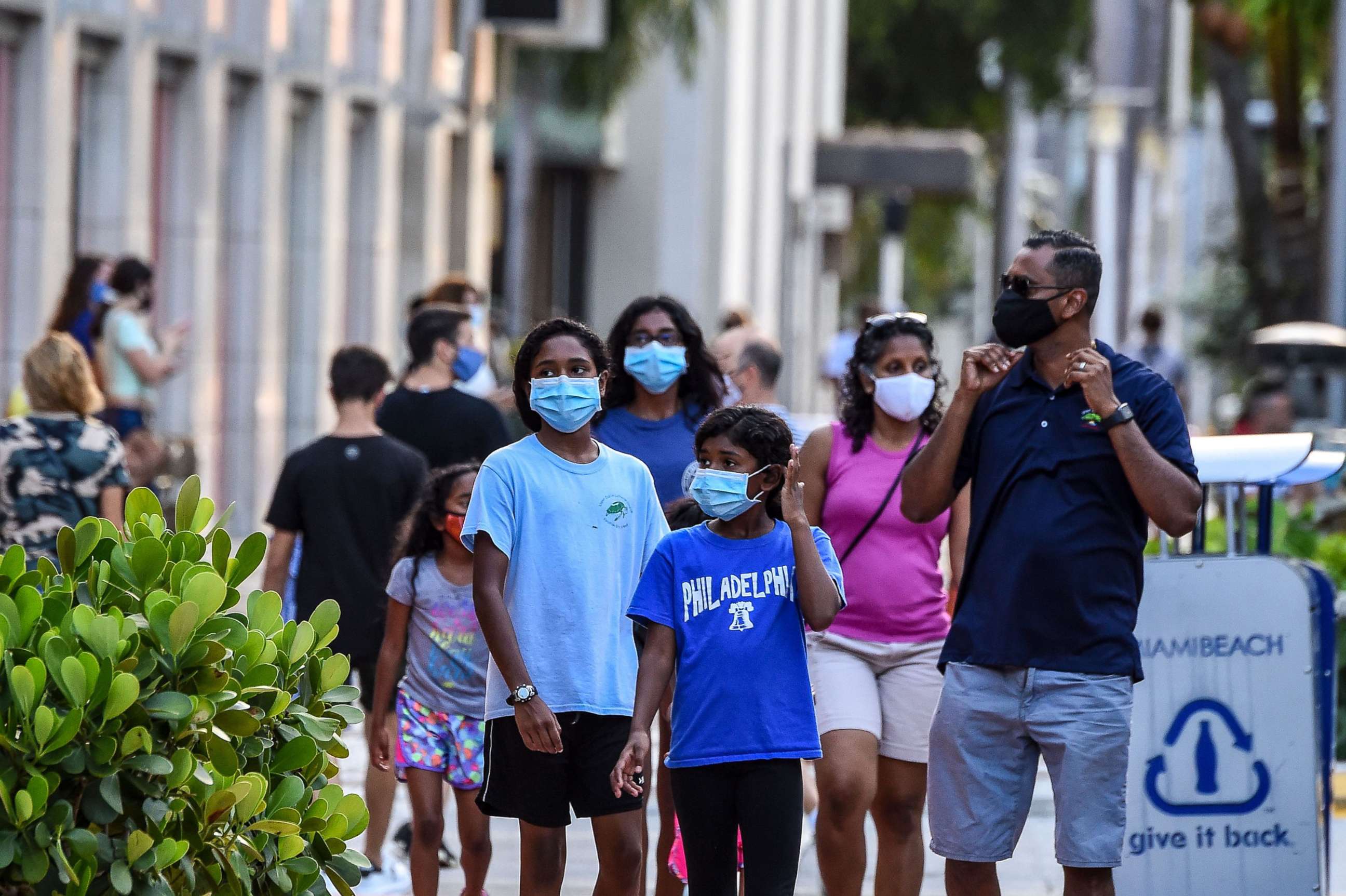 PHOTO: A family wearing facemasks walks at a shopping centre in Miami Beach, Fla., on June 29, 2020.
