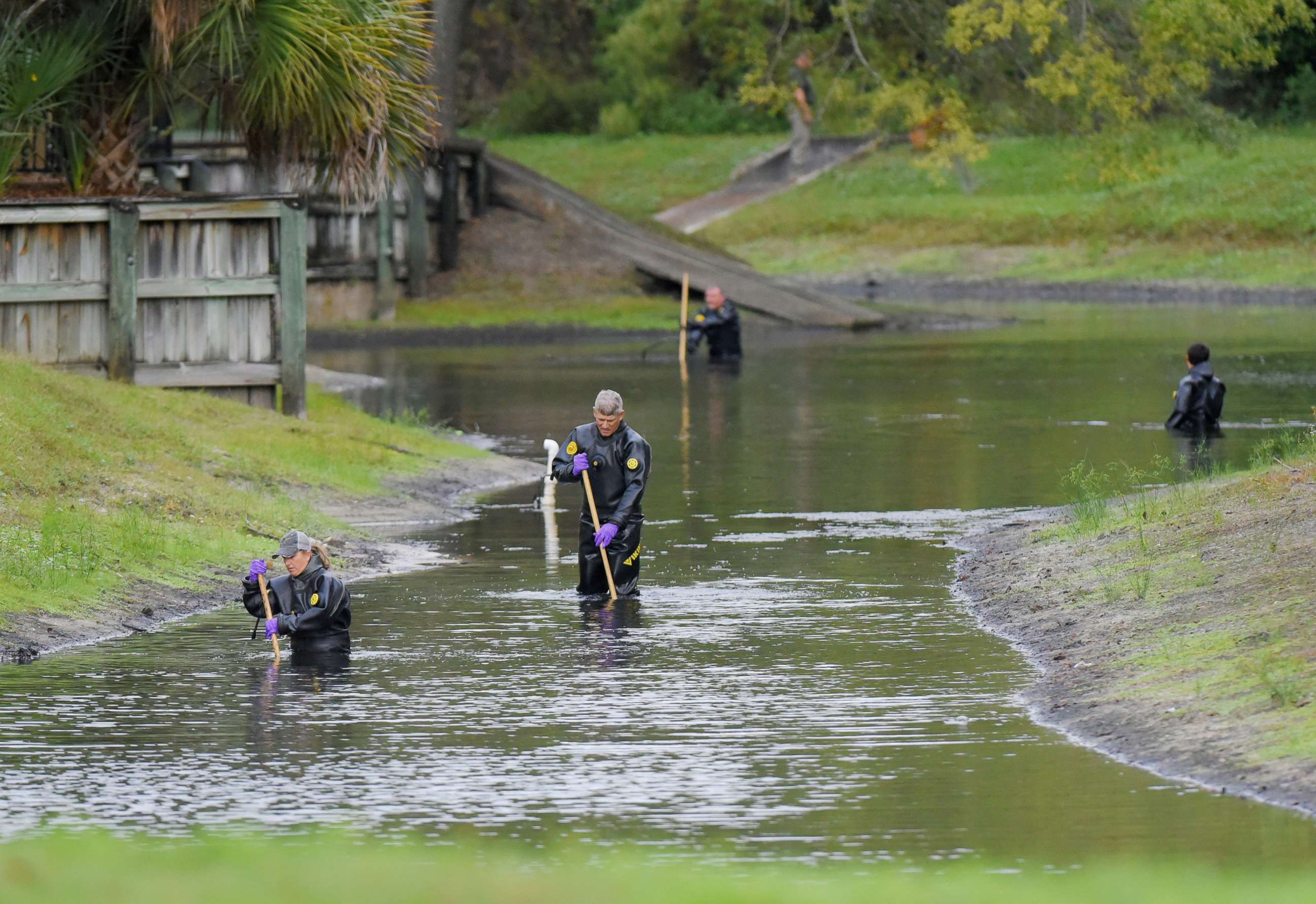 PHOTO: Law enforcement investigators in dry suits search the small retention pond near the entrance of the Southside Villas apartment complex in Jacksonville, Fla., Nov. 6, 2019.