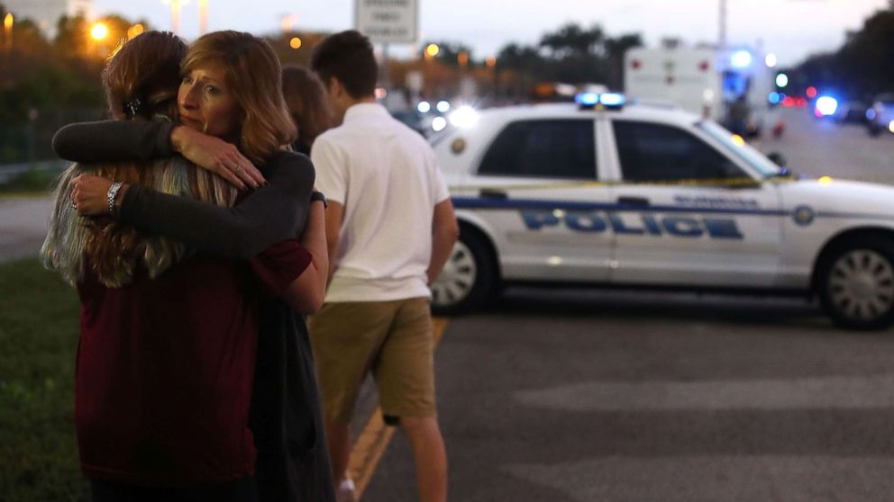 PHOTO: Kristi Gilroy hugs a young woman at a police check point, Feb. 15, 2018, near the Marjory Stoneman Douglas High School where 17 people yesterday were killed by a gunman in Parkland, Fla.