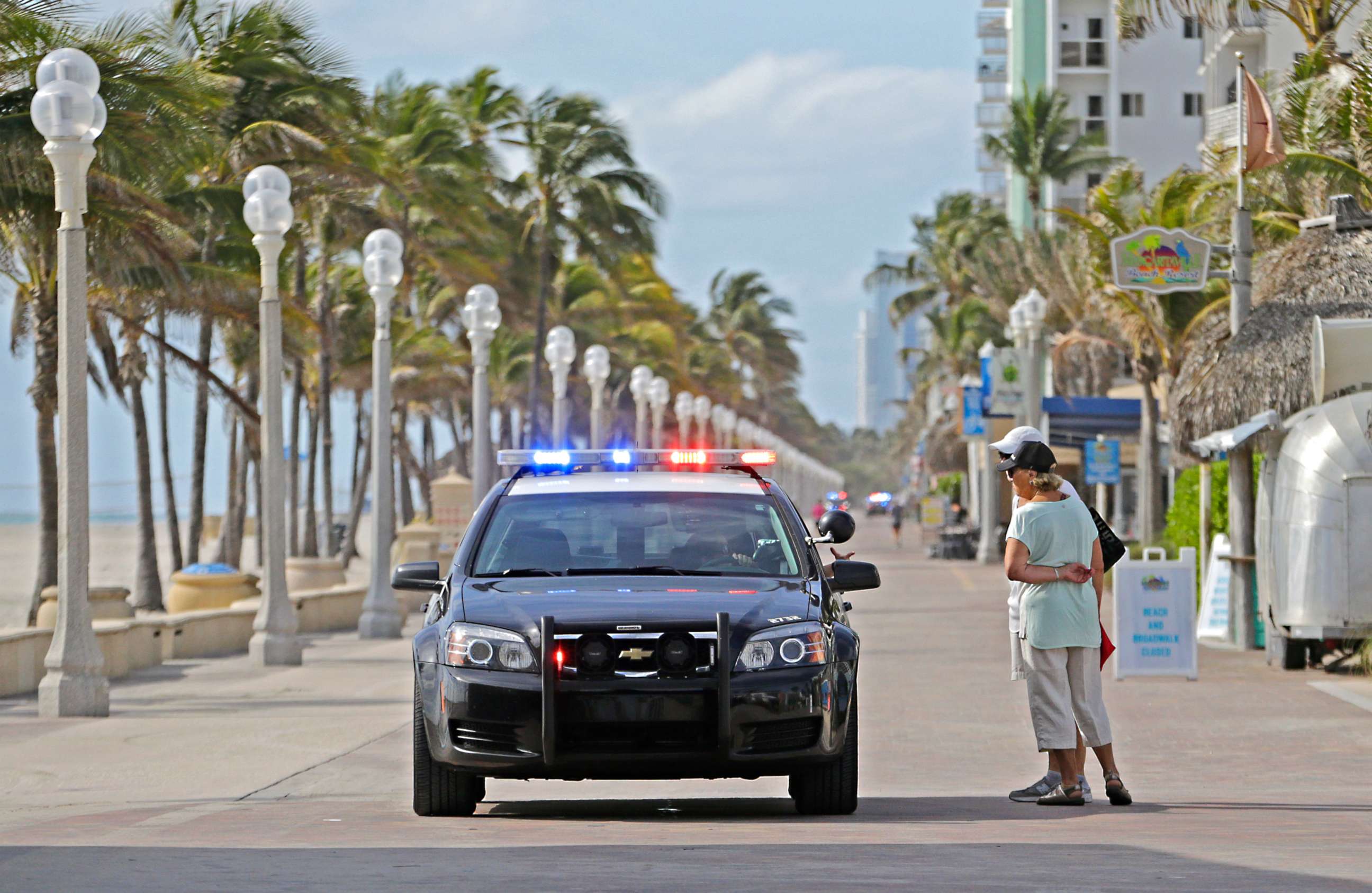 PHOTO: Hollywood Beach Police talk with visitors at Hollywood Boardwalk, which is one of the many places that are not open to the public due to coronavirus, March 18, 2020, in Hollywood, Fla.