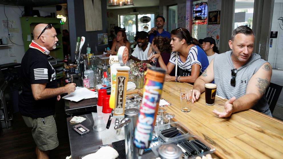 PHOTO: Bar patrons attend the reopen Florida "maskless" rally and dinner held at 33 & Melt restaurant to protest mandatory face mask restrictions during the coronavirus pandemic in Windermere, Fla., July 11, 2020.
