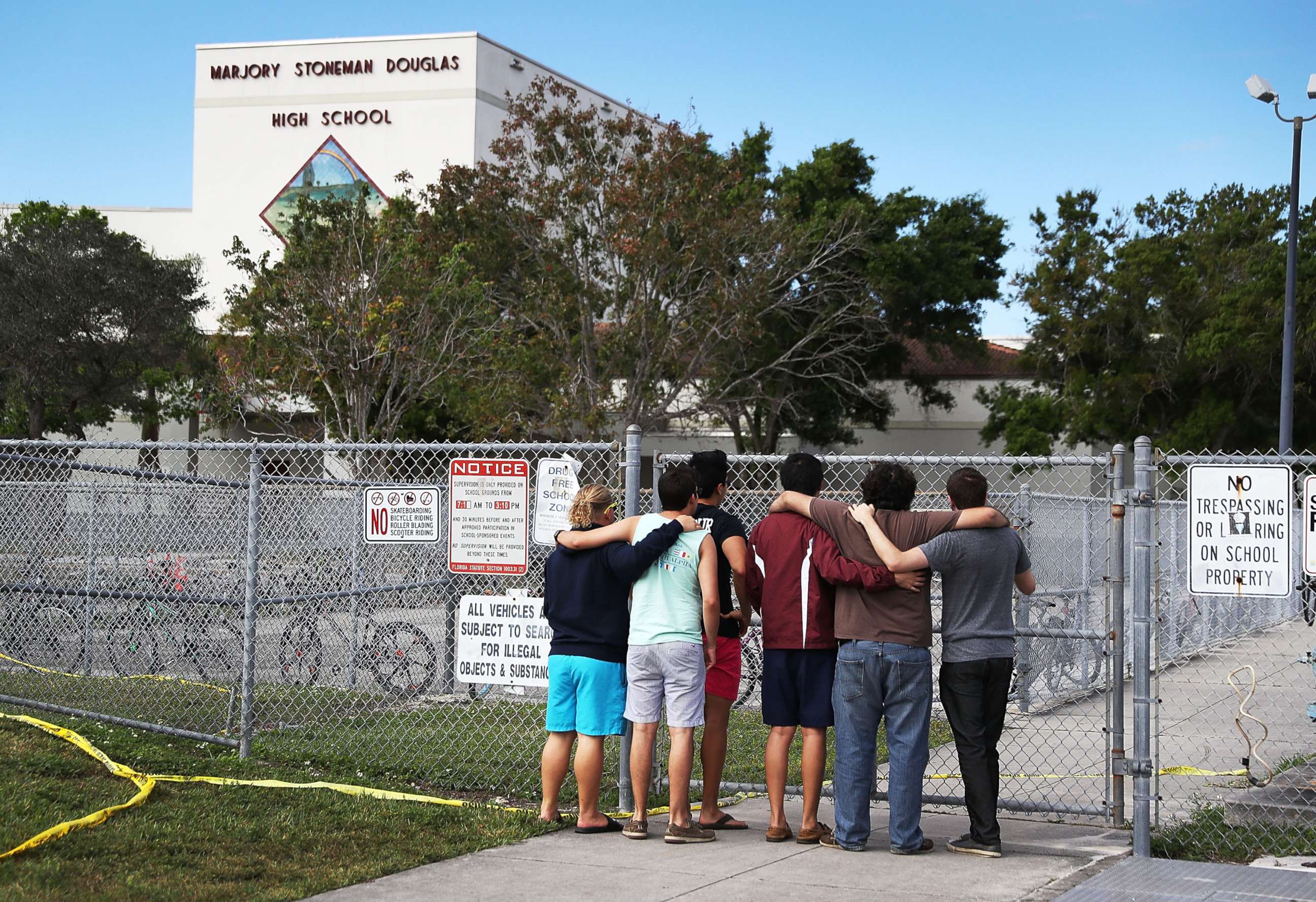 PHOTO: People look on at the Marjory Stoneman Douglas High School, Feb. 18, 2018, in Parkland, Florida.