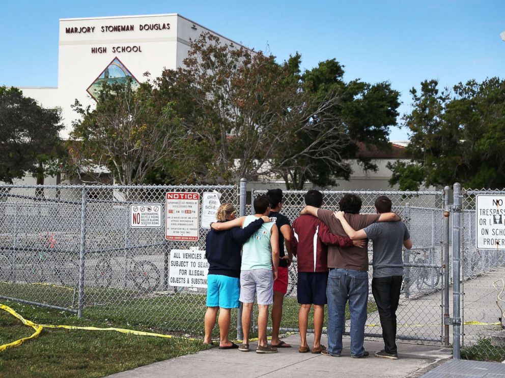 PHOTO: People look on at the Marjory Stoneman Douglas High School, Feb. 18, 2018, in Parkland, Florida.