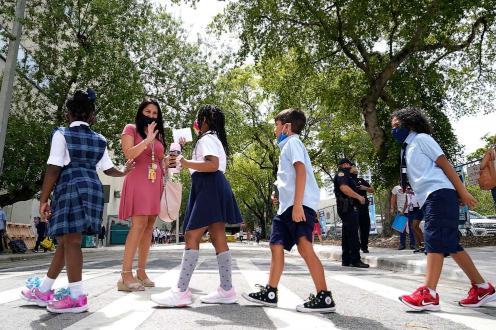 PHOTO: In this Aug. 23, 2021, file photo, teacher Vanessa Rosario greets students outside of iPrep Academy on the first day of school, in Miami.