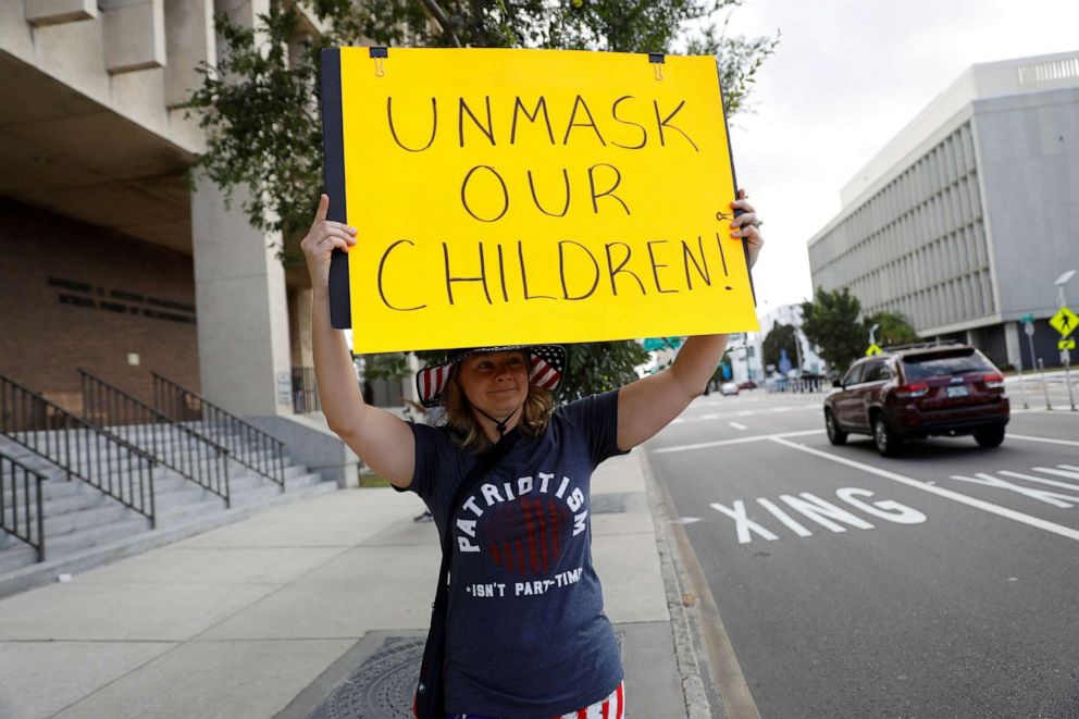 PHOTO: A protester who is against the school mask mandate, enacted to help slow the spread of COVID-19, stands outside with a sign at a Hillsborough County School Board meeting in Tampa, Fla., May 18, 2021.