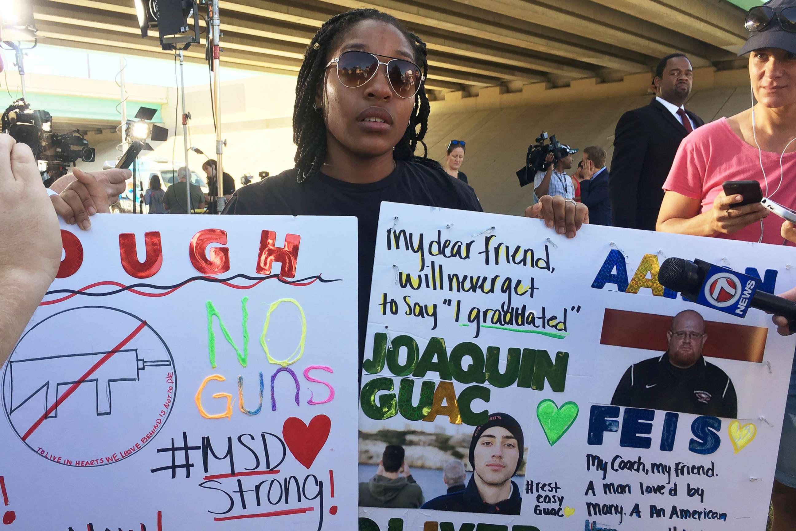 PHOTO: Tyra Hemans, a 19-year-old senior at Marjory Stoneman Douglas High School, sobs as she holds signs honoring slain teachers and friends near the police cordon around the school in Parkland Fla., Feb. 15, 2018.