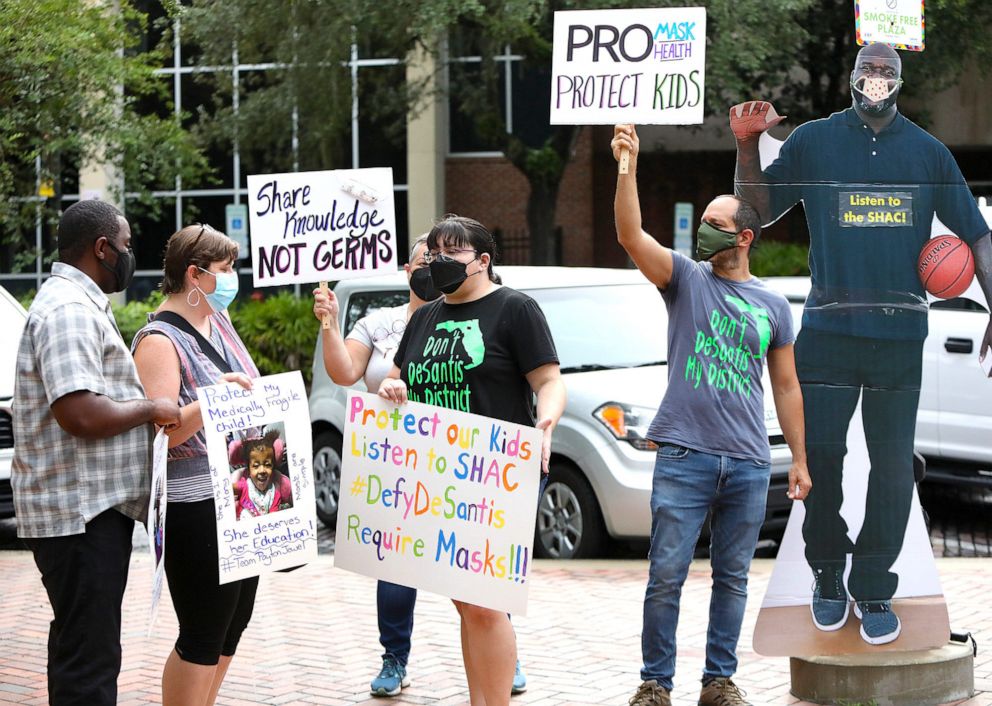 PHOTO: Parents with the Education Advocates of Alachua County take part in a rally to show support that kids should be required to wear face coverings in Alachua County Schools this year in Gainesville, Fla., Aug. 3, 2021. 