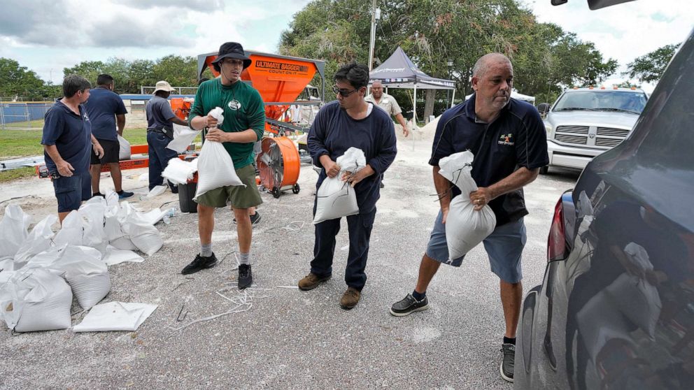 PHOTO: Members of the Tampa, Fla., Parks and Recreation Dept., help residents load sandbags, Aug. 28, 2023, in Tampa, Fla.