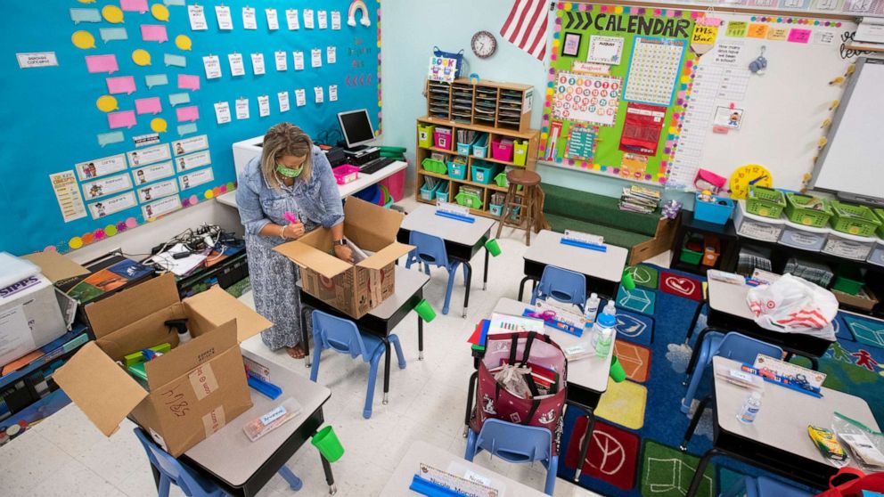 PHOTO: Nina Bac works to set up each kids desk including their individual school supply kit which each student will have on their desk in her kindergarten classroom at Macfarlane Park IB Elementary, Aug. 21, 2020 in Tampa.