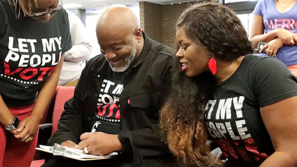 PHOTO: In this Jan. 8, 2019, file photo, former felon Desmond Meade and president of the Florida Rights Restoration Coalition, left, fills out a voter registration form as his wife Sheena looks on at the Supervisor of Elections office in Orlando, Fla.