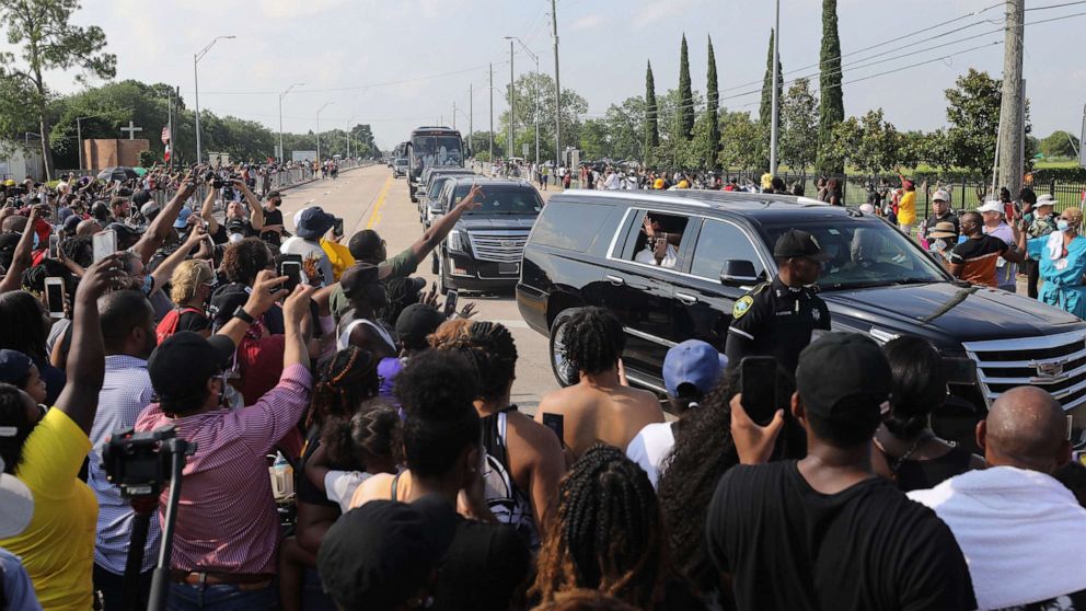 PHOTO: Mourners in procession vehicles pass people in the street viewing the George Floyd funeral procession moments before entering Houston Memorial Gardens Cemetery for Floyd's burial, June 9, 2020, in Pearland, Texas. 