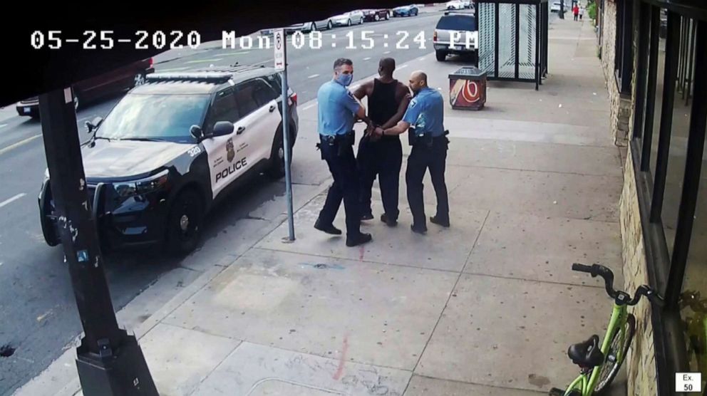 PHOTO: In an image from video, Minneapolis Police Officers Thomas Lane, left, and J. Alexander Kueng, right, escort George Floyd, center, to a police vehicle outside Cup Foods in Minneapolis, May 25, 2020.