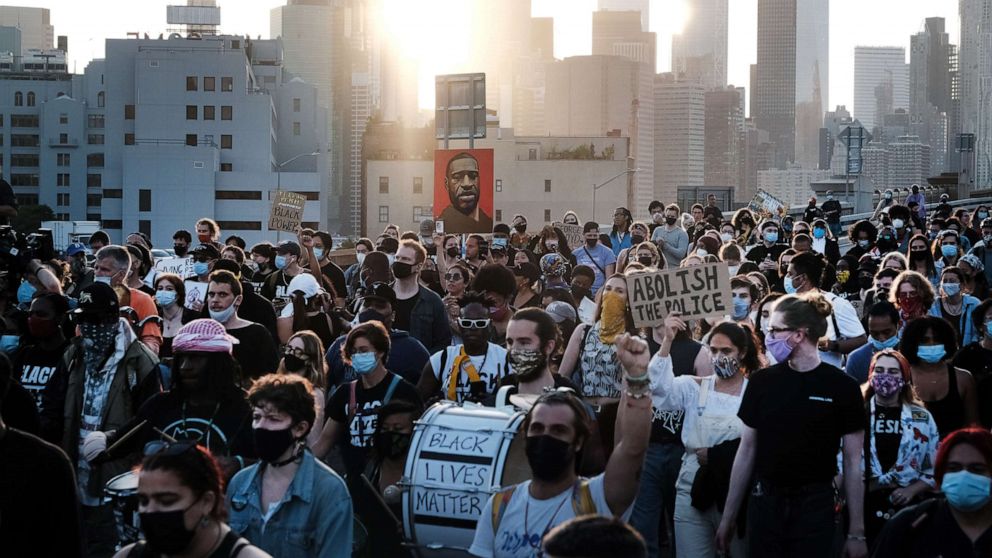 PHOTO: Demonstrators march across the Brooklyn Bridge to honor George Floyd on the one year anniversary of his death, May 25, 2021, in New York City.