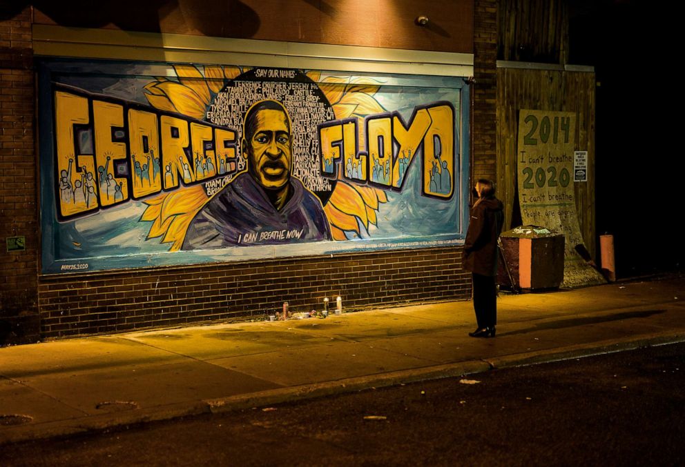PHOTO: A woman looks at a mural depicting George Floyd on the wall of Cup Foods, May 25, 2022, in Minneapolis.