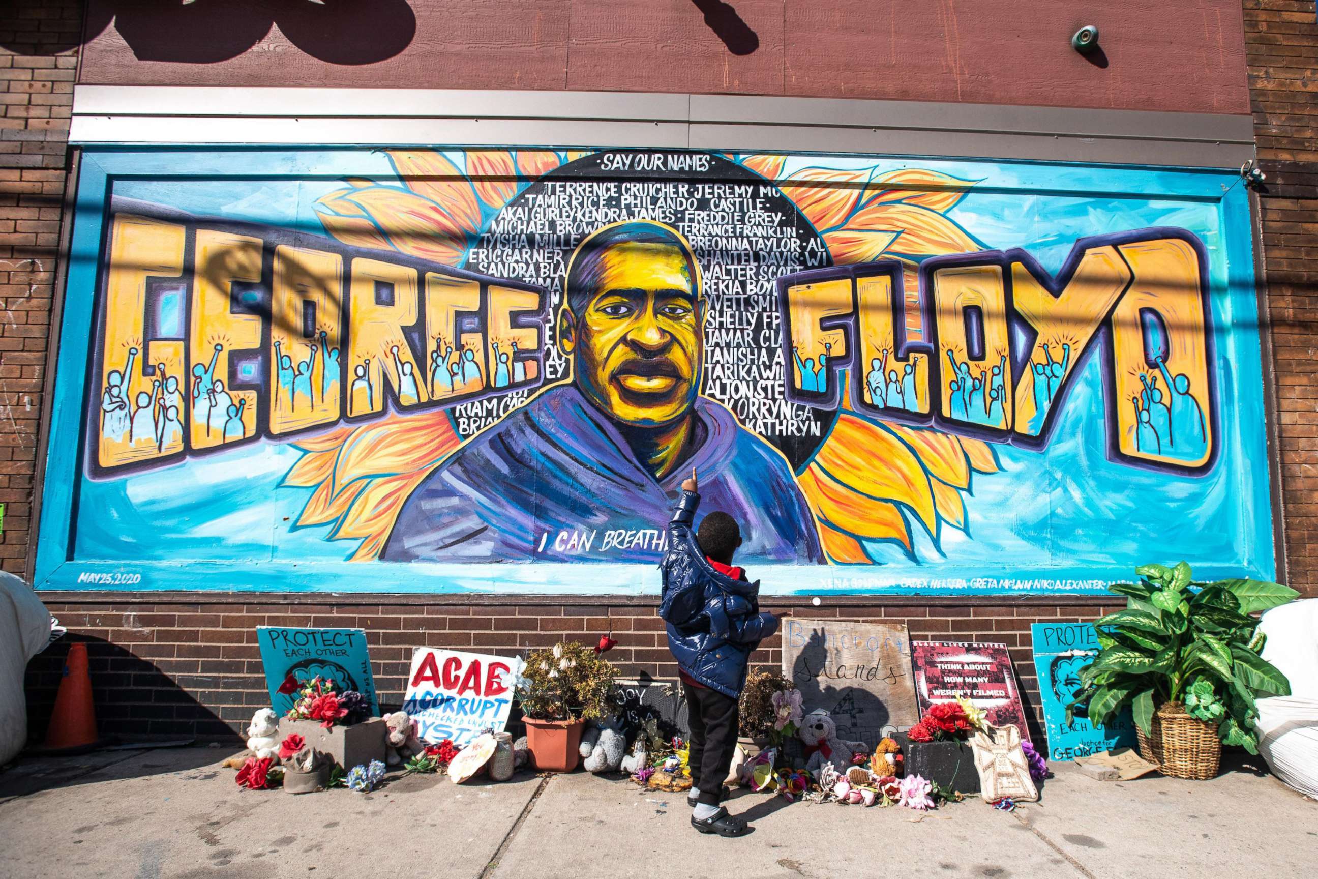 PHOTO: A child looks up at the memorial to George Floyd, April 1, 2021, outside Cup Foods in Minneapolis.