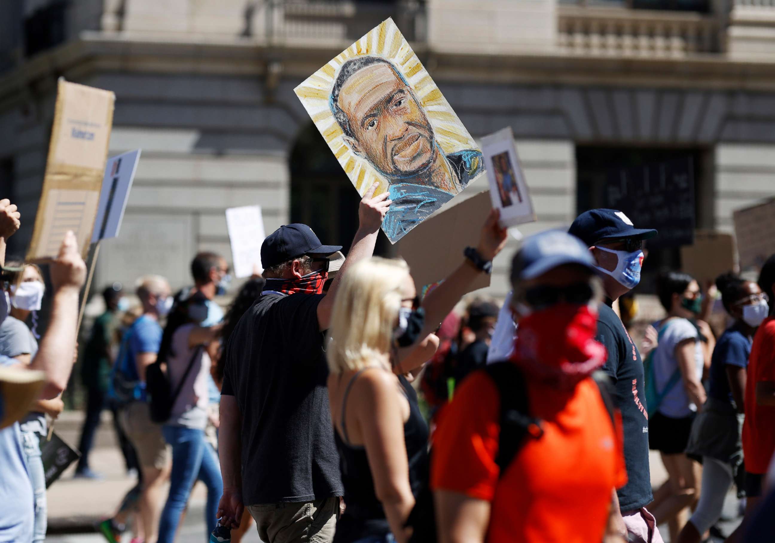 PHOTO: A placard with a portrait of George Floyd is held above demonstrators as they march calling for more oversight of the police, June 7, 2020, in Denver.