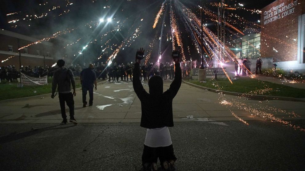PHOTO: Fireworks explodes over a protestor with his hands up during a protest against the death in Minneapolis police custody of African-American man George Floyd, in Ferguson, Missouri, May 30, 2020.