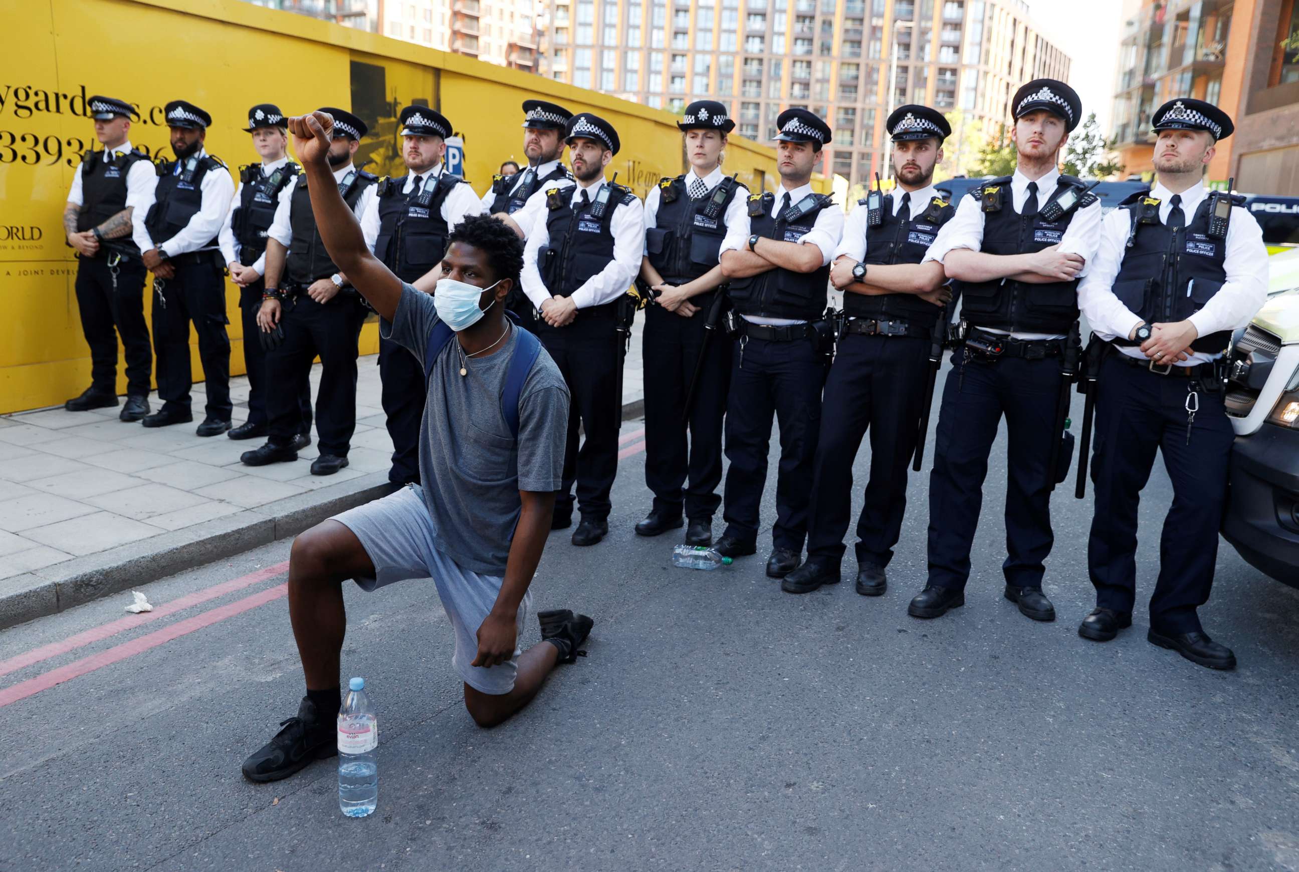 PHOTO: A man wearing a protective face mask kneels in front of police officers during a protest against the death in Minneapolis police custody of African-American man George Floyd near the U.S. Embassy, London, May 31, 2020.