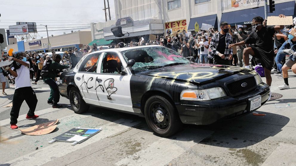 PHOTO: An LAPD vehicle begins to burn after being set alight by protestors during demonstrations following the death of George Floyd, May 30, 2020, in Los Angeles.