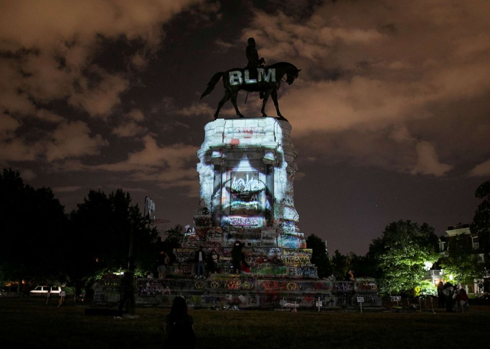 PHOTO: Artist Dustin Klein projects an image of George Floyd onto the statue of Confederate General Robert E. Lee in Richmond, Va., June 18, 2020.