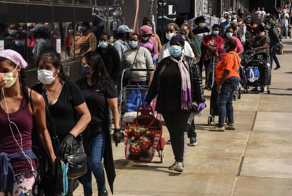 PHOTO: People wait on a long line to receive a food bank donation at the Barclays Center on May 15, 2020, in the Brooklyn borough in New York.