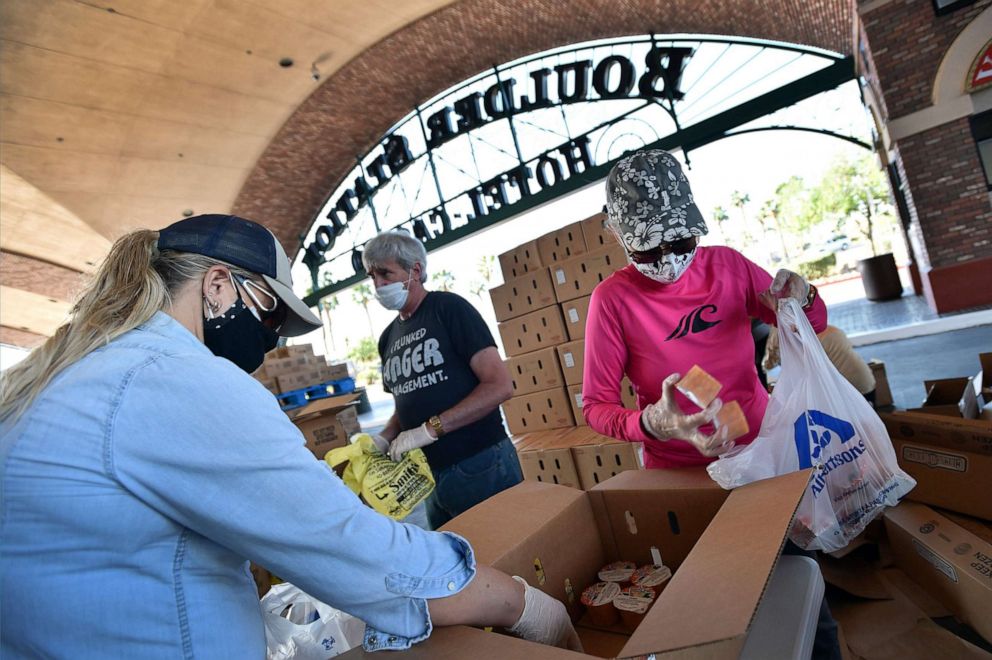 PHOTO: Volunteers prepare groceries to be given out at a drive-thru Three Square Food Bank emergency food distribution site at Boulder Station Hotel & Casino in response to an increase in demand amid the coronavirus pandemic, April 29, 2020, in Las Vegas.