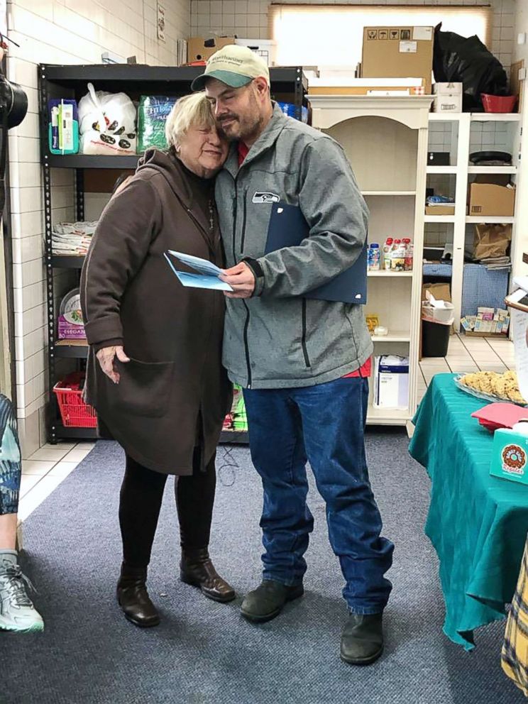 PHOTO: Kevin Booth and Anita Miller hug after Miller presented Booth with thank you cards in honor of his good deed at Sumner Community Food Bank, on Nov., 29, 2018.