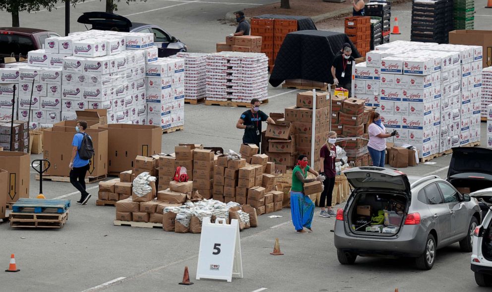 PHOTO: Workers and volunteers help load cars with food at a San Antonio Food Bank drive-through distribution during the coronavirus pandemic in San Antonio, April 7, 2020.