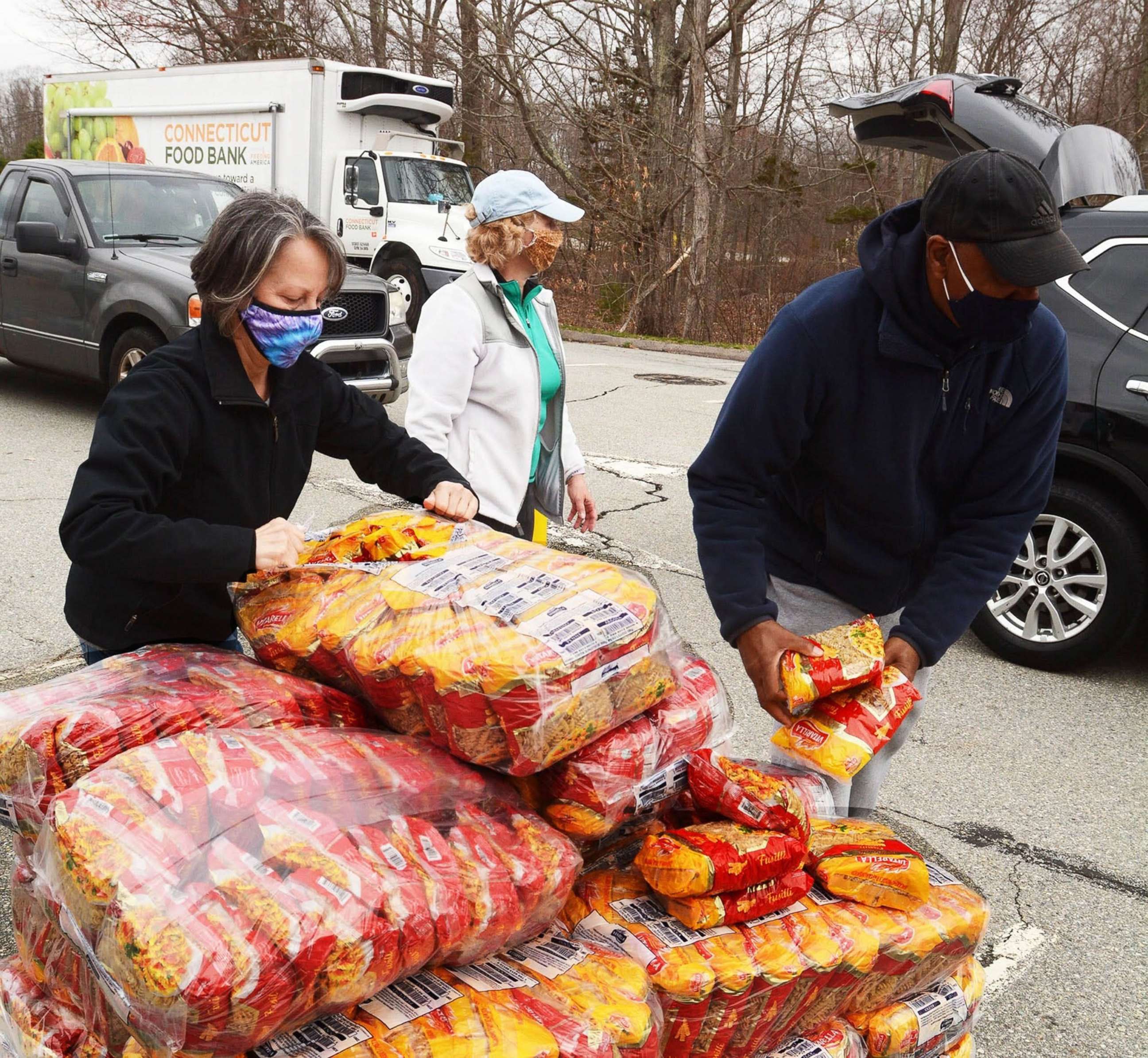 PHOTO: Volunteers load pasta into cars during the Connecticut Food Bank's weekly food distribution in the Foxwoods employee parking in Norwich, Conn., April 12, 2021.