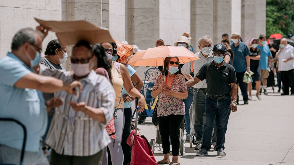 PHOTO: New Yorkers in need wait in a long line to receive free produce, dry goods, and meat at a Food Bank For New York City distribution event at Lincoln Center on July 29, 2020, in New York.