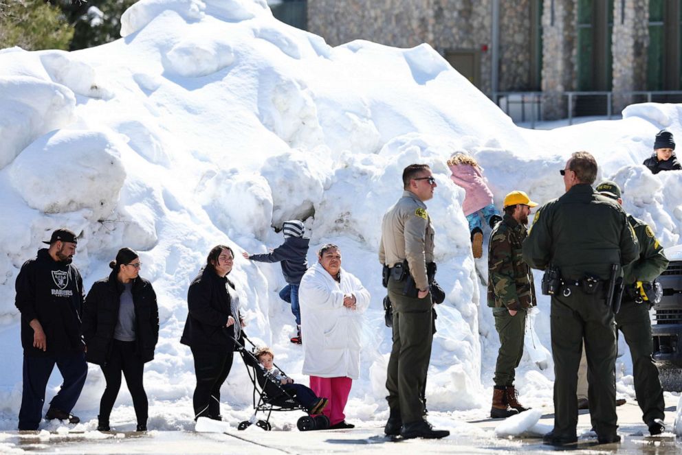 PHOTO: Residents wait in line to receive donated food outside the local grocery store, which was severely damaged when its roof collapsed under the weight of several feet of snow, on March 3, 2023, in Crestline, Calif.