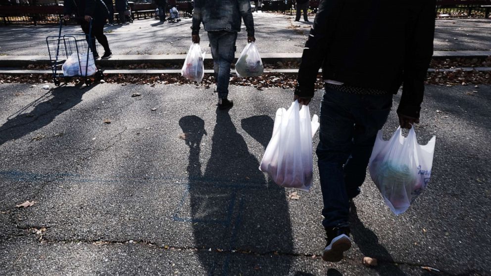 PHOTO: People receive a free Thanksgiving turkey and other holiday food staples outside of a housing project in Harlem, Nov. 23, 2021, in New York City.