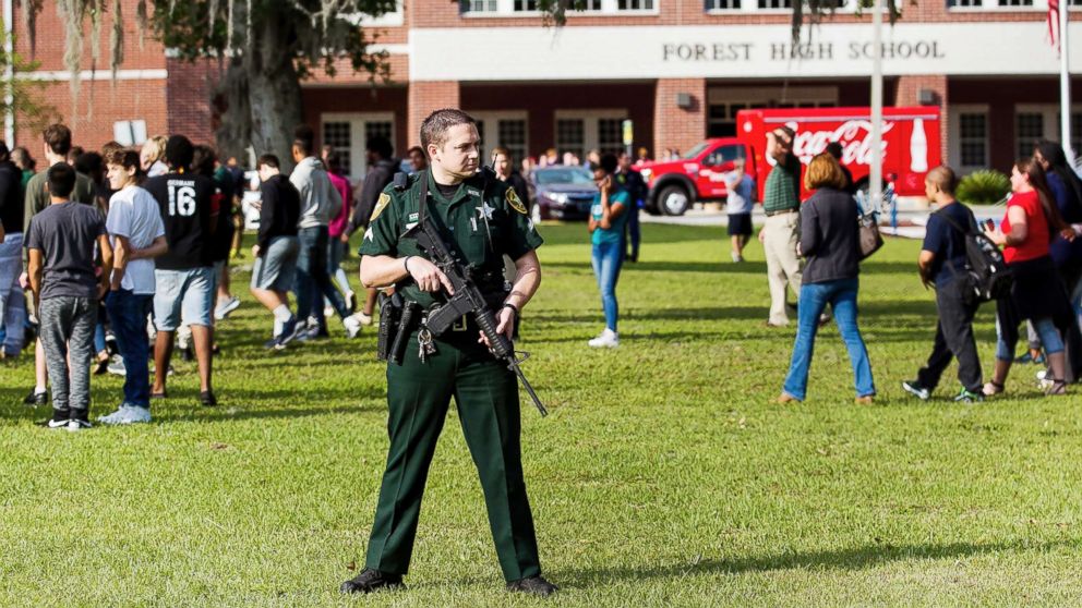 A Marion County Sheriff's Deputy stands outside Forest High School as students exit the school after a school shooting occurred on April 20, 2018 in Ocala, Fla.
