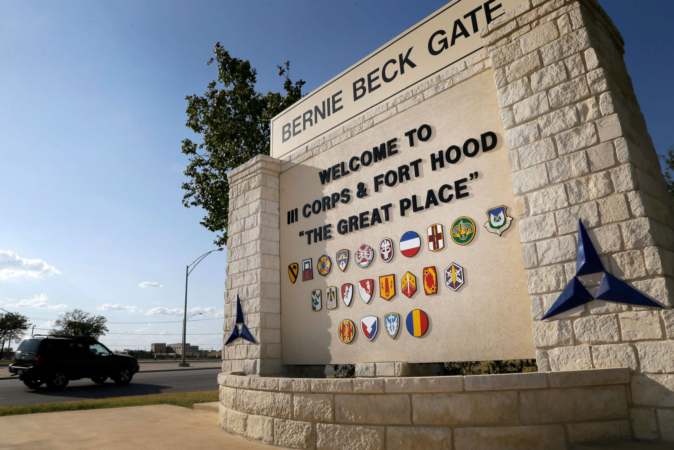 PHOTO: Traffic flows through the main gate past a welcome sign, July 9, 2013, in Fort Hood, Texas.