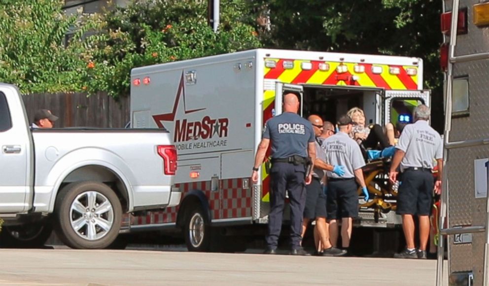 PHOTO: A woman is lifted into an ambulance as police investigate a robbery and shooting at Veritex Bank, July 19, 2018, in Fort Worth, Texas.