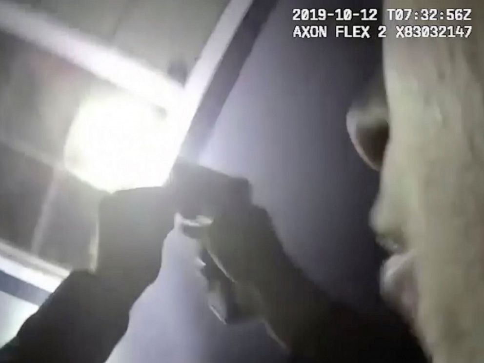 PHOTO: In this Saturday, Oct. 12, 2019, image made from a body camera video released by the Fort Worth Police Department an officer shines a flashlight into a window in Fort Worth, Texas.