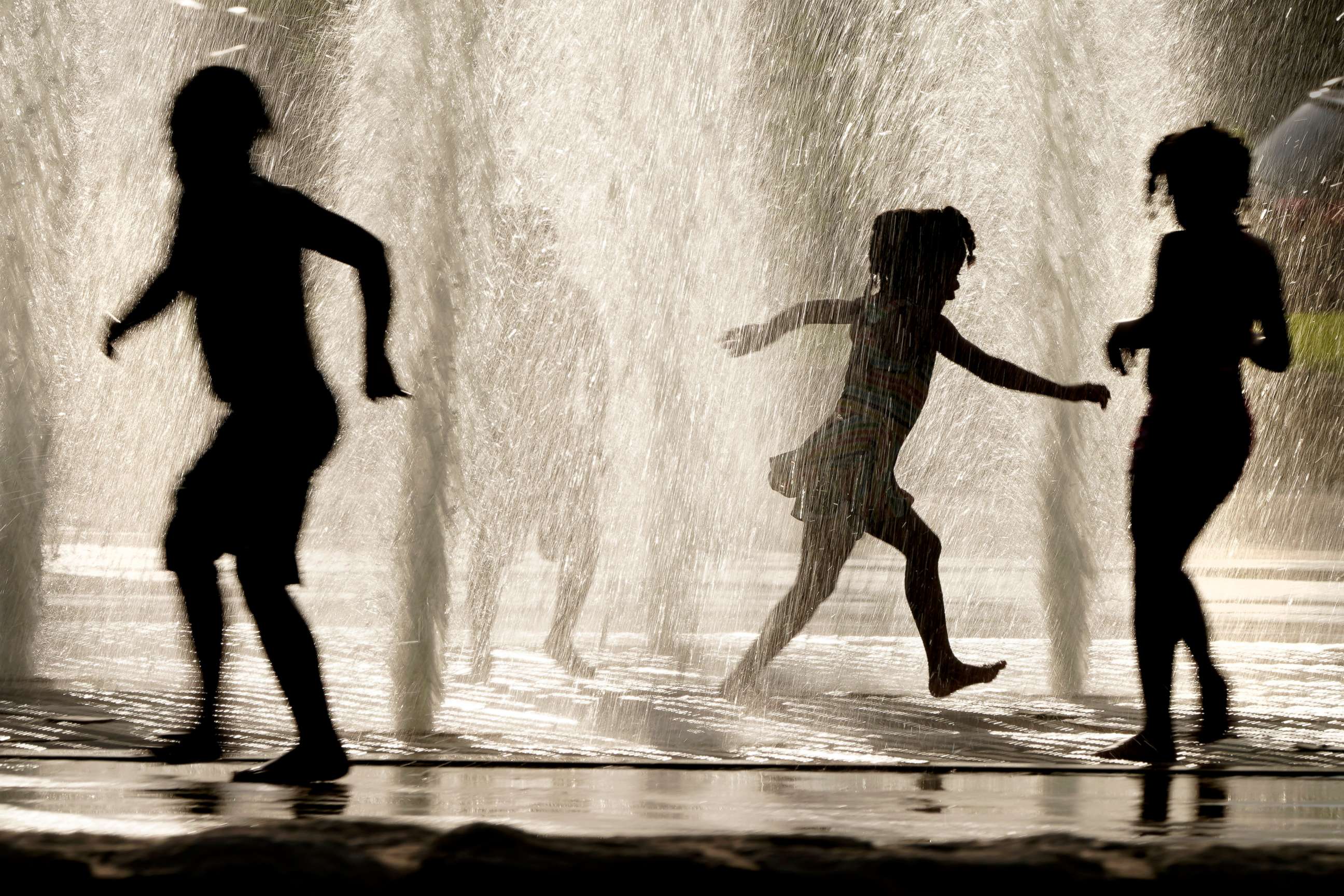 PHOTO: Kids cool off in a fountain at a park as summer-like temperatures move into the region, June 5, 2021, in Kansas City, Mo.