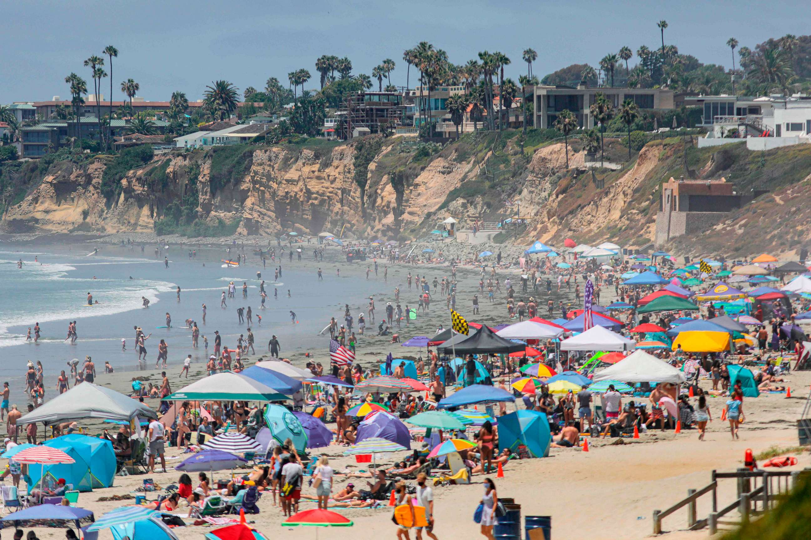PHOTO: Beachgoers are seen along the shore in the Pacific Beach area of San Diego, California, on July 4, 2020.