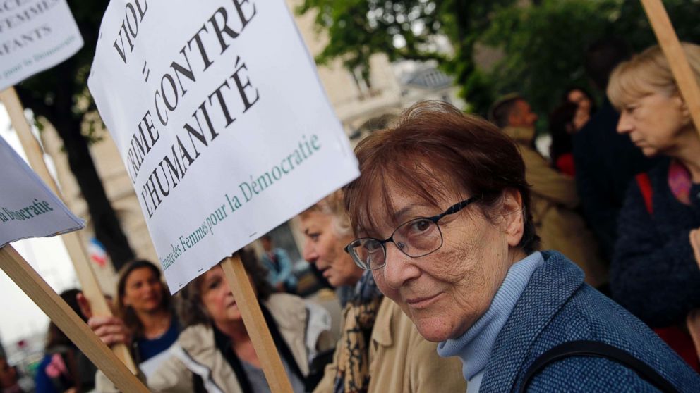 A woman holds a banner reading: Rape: crime against humanity, as she demonstrates in front of National Assembly in Paris, May 15, 2018.