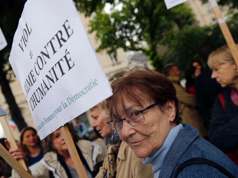 PHOTO: A woman holds a banner reading: Rape: crime against humanity, as she demonstrates in front of National Assembly in Paris, May 15, 2018.