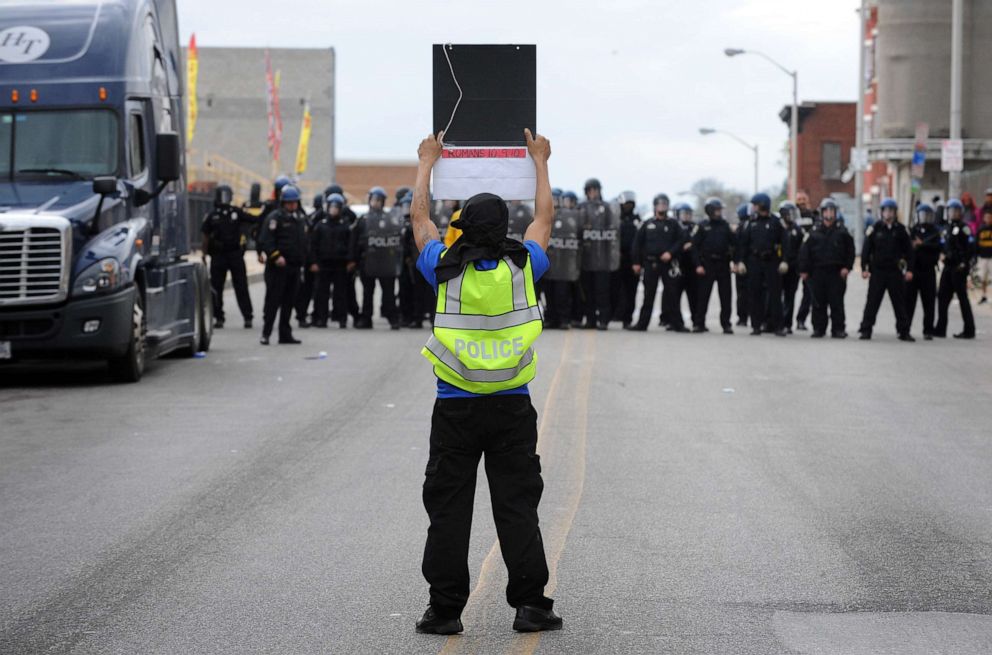 PHOTO: A protester with a police vest faces members of the Baltimore Police Department, April 27, 2015, during unrest following the funeral of Freddie Gray in Baltimore.