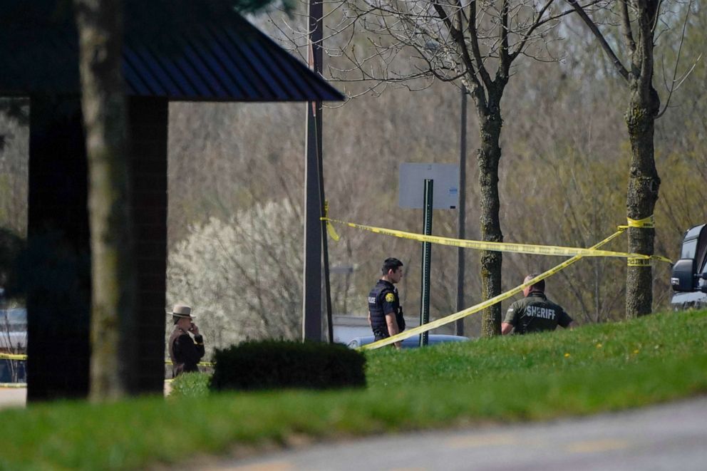 PHOTO: Police stand around an area cordoned off by police tape on Progress Court, near the scene of a shooting at a business park, in Frederick, Md., April 6, 2021.